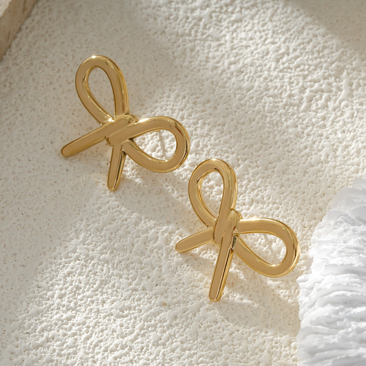 Clous d'Oreilles Dorés Nœud Couture Chic